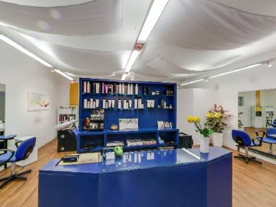 Verkaufsbereich mit blauer Theke und Haarpflegeprodukten bei Coiffeur Hair Care in Männedorf 